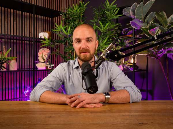 Podcast host recording at the wooden table of Kreators by bridgr in Lisbon